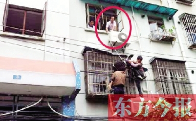 施救現(xiàn)場(chǎng)，劉鵬（圈內(nèi)）先用繩子捆住老太確保安全 勞動(dòng)報(bào)記者 郭娜 供圖