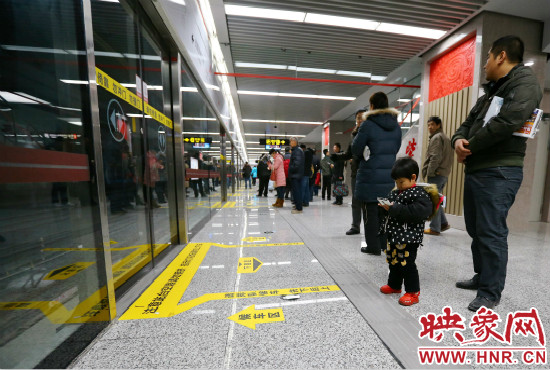 小朋友在等候區(qū)內(nèi)等待地鐵。