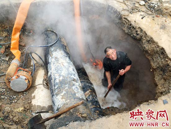 最下邊的一根熱力管道有一個(gè)口子正“哧哧”往外噴著熱水