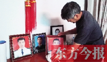 沉浸在悲痛之中的魯有海，擦拭著孩子的遺照