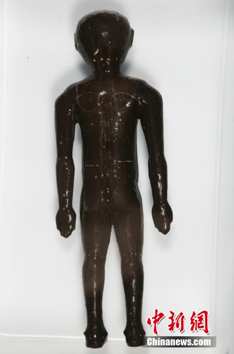 圖為出土的人體經(jīng)穴漆俑。