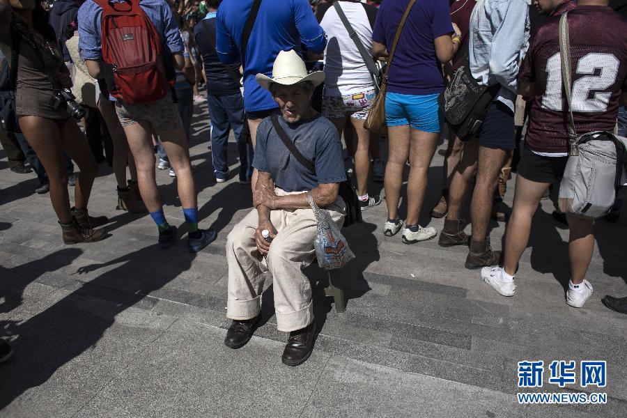 一名男子坐在參加不穿褲子搭地鐵的人群邊小憩。