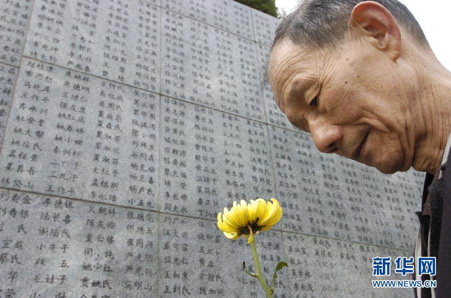 2006年4月5日，74歲的南京大屠殺幸存者佘子清手捧鮮花，祭奠被日軍殺害的母親。