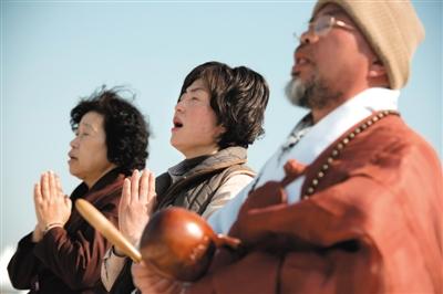 23日，一名僧侶引領(lǐng)人們?yōu)樗勒咂矶\。