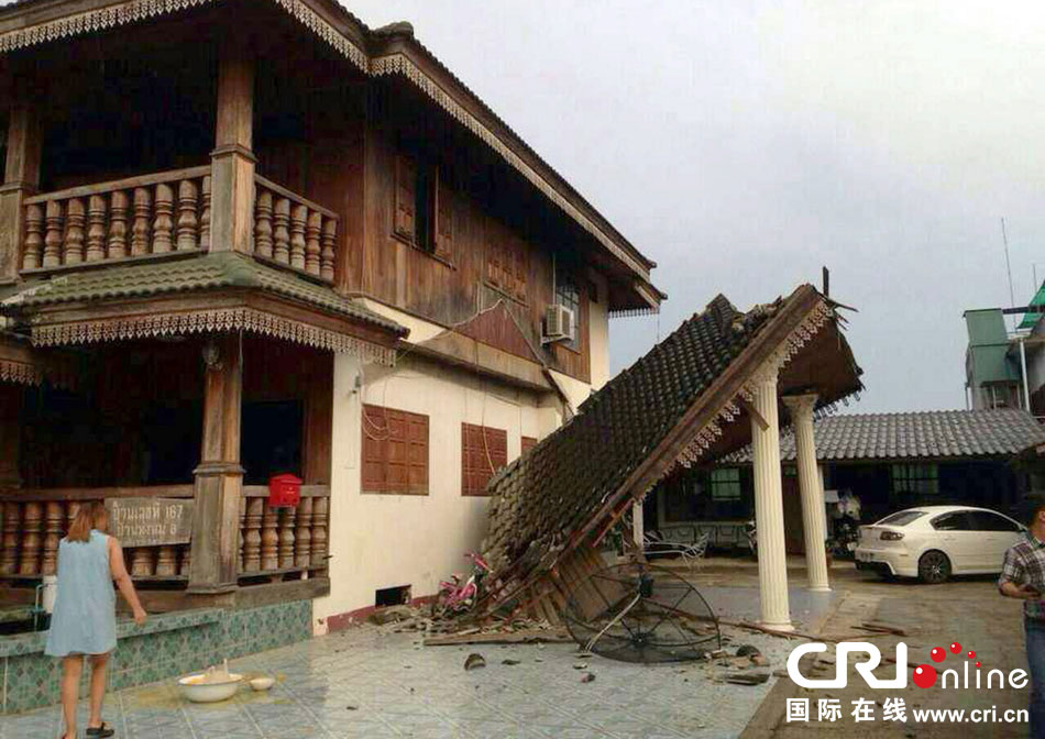 當?shù)貢r間2014年5月5日，泰國清萊，一名婦女看著受損的房屋。 圖片來源：東方IC