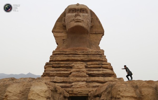 石家莊郊外，一名男子與山寨版獅身人面像合影留念。