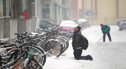小伙子跪在樓前，一直抬頭看著樓上。 孫立國/攝