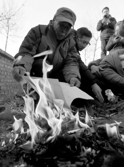 李三仁在兒子墳前焚燒再審無(wú)罪判決文書的復(fù)印件。新華社發(fā)