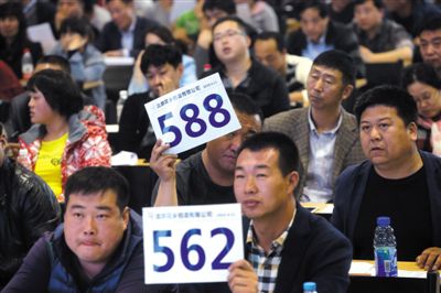 昨日，拍賣現(xiàn)場競拍者舉牌競拍。新京報記者