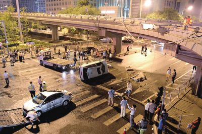 路虎沖下國貿(mào)橋砸中一輛起亞轎車，橋上厚達幾十厘米的水泥護欄被撞斷，碎石四處散落，數(shù)十群眾在現(xiàn)場圍觀。