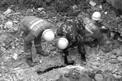 搜救人員正在用探視儀器觀看被掩埋層的情況。