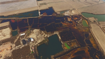 4月19日，廊坊市大城縣南趙扶鎮(zhèn)，津保路以北約八九百米處，一個(gè)巨大的污水坑中，水體呈現(xiàn)紅褐色。 新京報(bào)記者 尹亞飛 攝