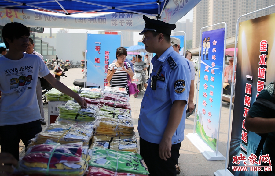 執(zhí)法人員勸導(dǎo)看守?cái)偽坏娜藛T搬離，停止非法占道經(jīng)營(yíng)。