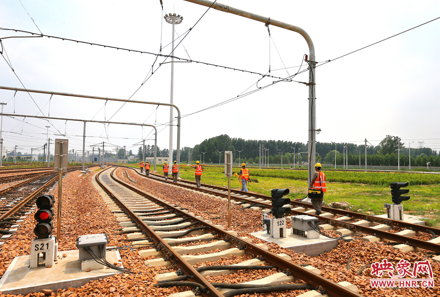 在太陽的直射下，檢修工人扛著沉重的設(shè)備向施工地點出發(fā)