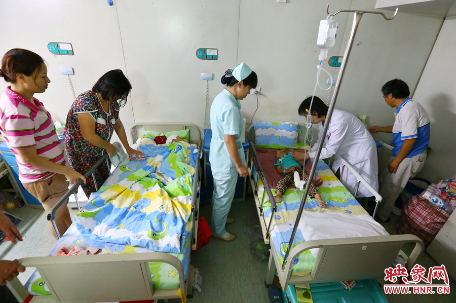 手術(shù)前，畫面右側(cè)的大龍正在接受醫(yī)生的檢查，左側(cè)的小龍還在熟睡。