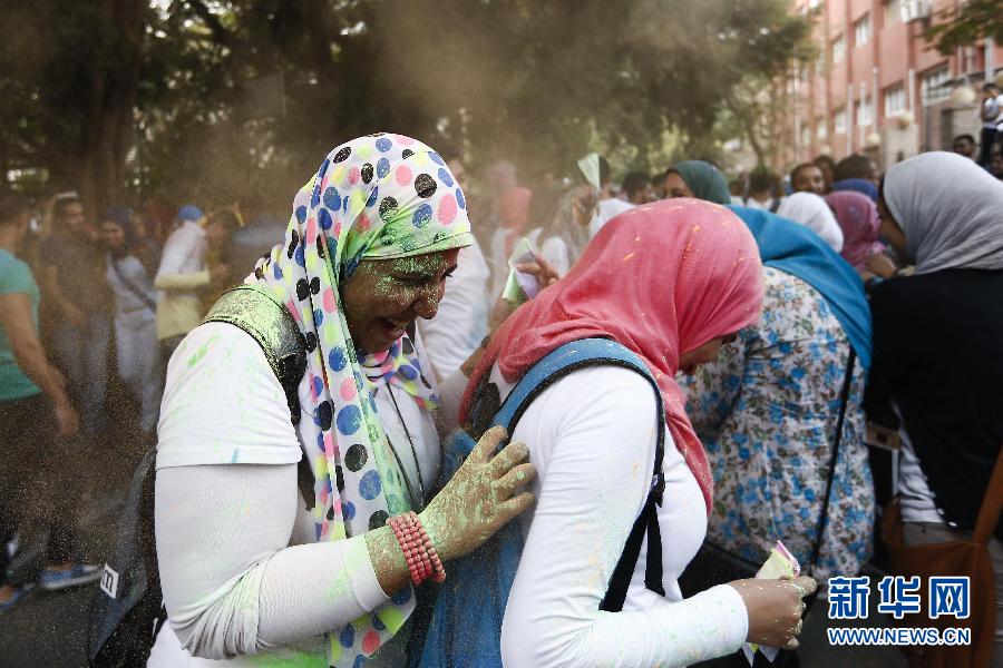 10月16日，在埃及首都開羅，兩名女青年在“彩色跑”活動中躲避人們拋撒的彩色粉末。