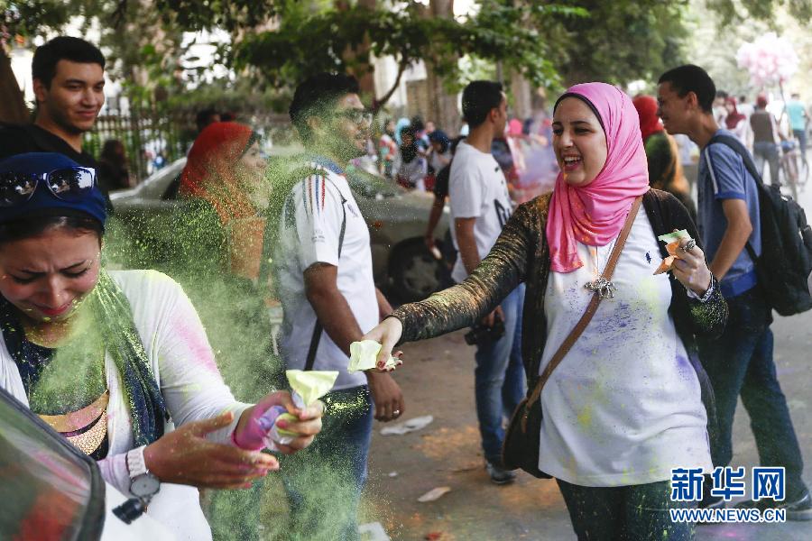 10月16日，在埃及首都開羅，一名女青年在“彩色跑”活動中拋撒彩色粉末。
