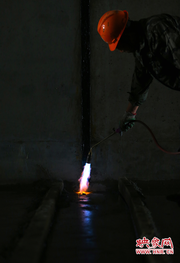 工人師傅用噴槍烘干地面，便于做防水處理