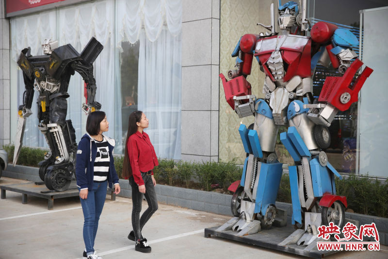 10月14日，市民在參觀河南省平頂山市寶豐縣一家企業(yè)門前的“變形金剛”。