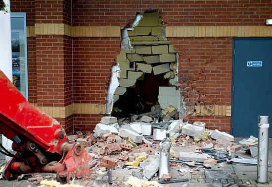 劫匪利用挖掘機(jī)的機(jī)械臂移走ATM機(jī)，留下滿地狼藉