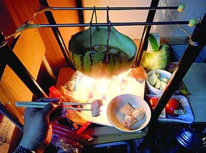 兩張椅子被面對(duì)面疊在一起，穿了兩根線的西瓜皮就懸空在椅腳中間，下面有蠟燭加熱，這就是西瓜火鍋。