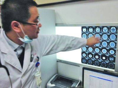 醫(yī)生在查看男孩的腦部CT片。薛馬義 攝