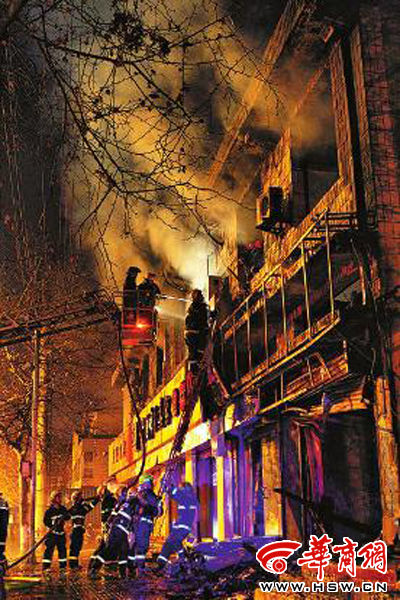 昨日22時(shí)10分，西安市豐慶路南小巷南口，消防官兵架梯子登上二樓施救 本組圖片由本報(bào)記者 閆文青 攝