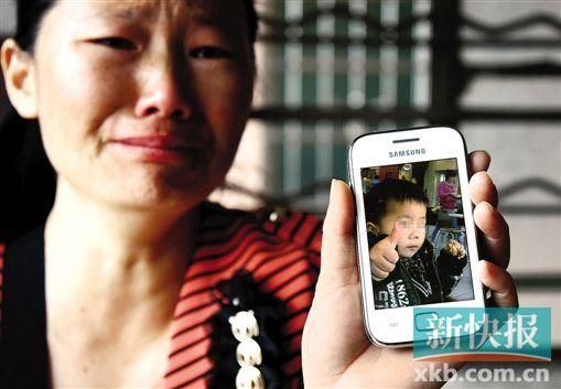 男童的舅媽拿著小益的照片,悲痛欲絕。 新快報記者 畢志毅 攝