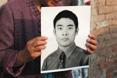 5月19日，朝陽(yáng)北路，母親捧著張東文的遺像。新京報(bào)記者 侯少卿 攝