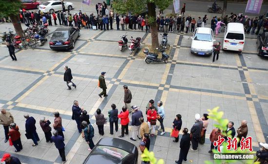 圖為10月28日，在江西九江市一家羊絨皮草服裝服飾博覽會現(xiàn)場，老人們正在頂著寒風(fēng)排隊(duì)等待領(lǐng)取10元代金劵。