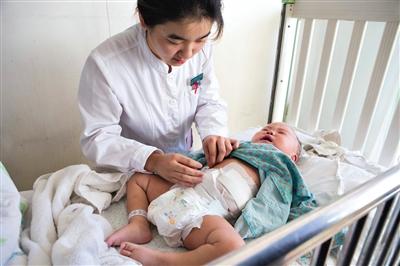 昨日，北京兒童醫(yī)院，護士為即將出院的被扎鋼針女嬰檢查傷口恢復情況。記者 高瑋 攝