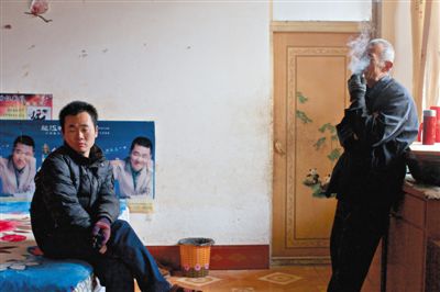 父親抽煙，兒子不語。逃跑的越南新娘，給袁迎賓父子帶來的是失落。新京報記者 周崗峰 攝