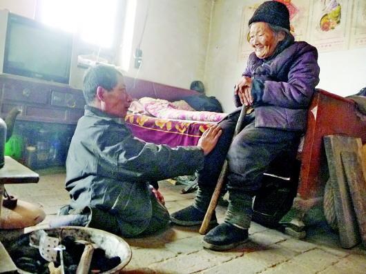 52歲的劉蘭山每天靠爬行照顧90歲的老母親。孫國祥 攝