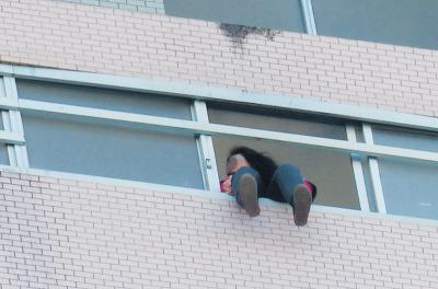 28樓的窗臺(tái)上坐著一名女子，其兩條腿耷拉在室外，不停地?cái)[動(dòng)。
