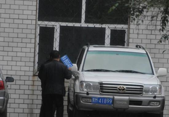 程父與程的“司機(jī)”在居住小區(qū)內(nèi)將黑AB0040車牌更換為黑M41899車牌，倆車牌號均為空號