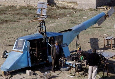 哈蒂姆·卡迪姆·薩爾曼正與工人交談，背后就是他正在制造的直升機(jī)