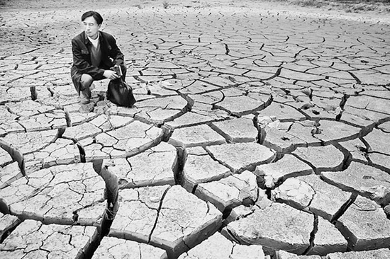蹲在干涸的田地里，焦裕祿為饑餓的百姓揪心不已 《焦裕祿》劇照