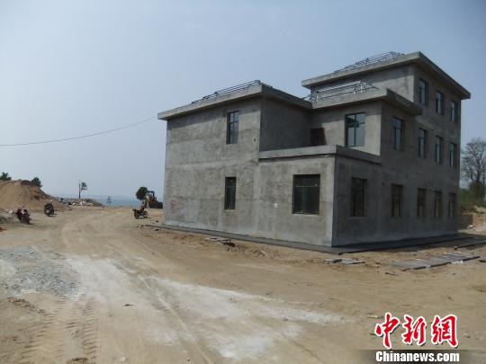 鴨河水庫庫區(qū)邊的新建別墅，一面墻上寫著“拆”，另一邊在加緊施工。吳揚(yáng)　攝